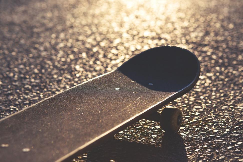 Free Image of Skateboard on the glowing pavement at sunset 