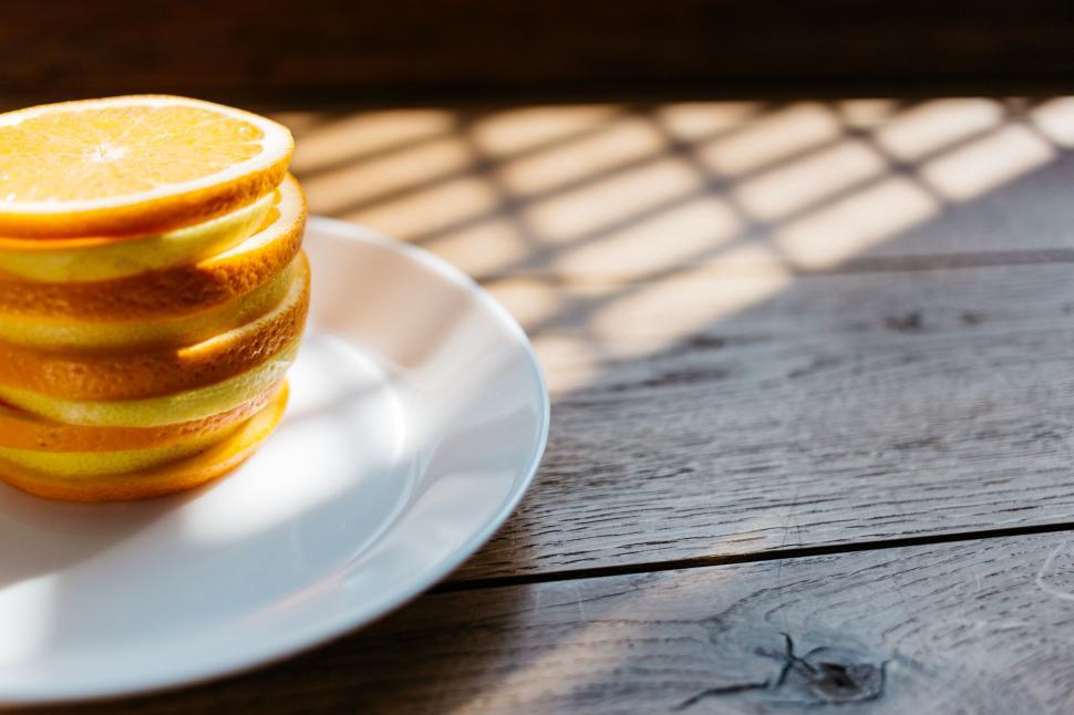 Free Image of Stack of freshly sliced oranges on a plate 