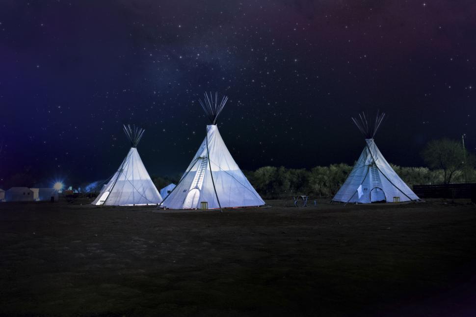 Free Image of Illuminated tipis under a starlit night sky 