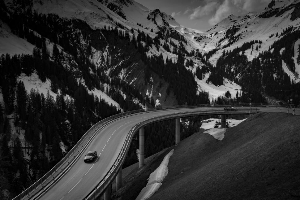 Free Image of Monochrome image of car on mountain road 