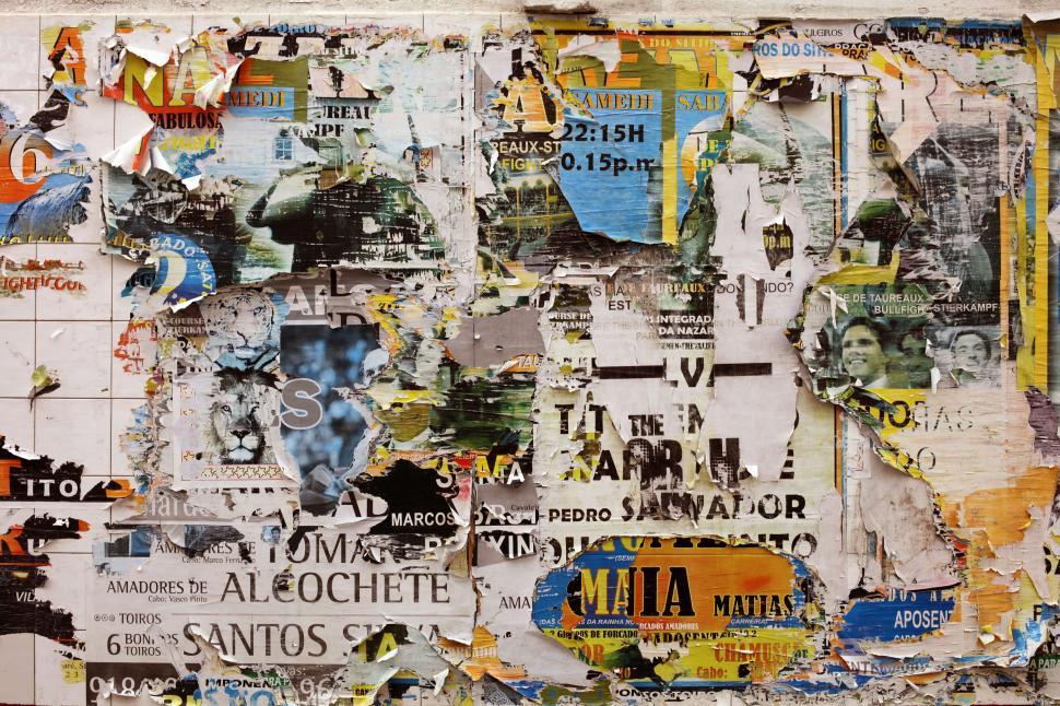 Free Image of Colorful collage of torn posters on a wall 