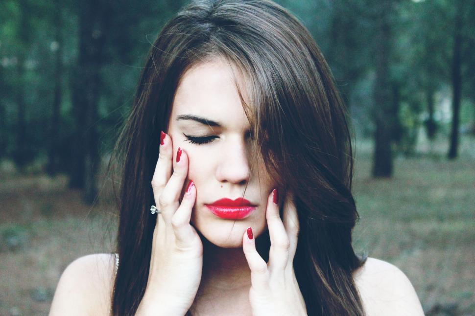 Free Image of Woman with closed eyes touching her face 