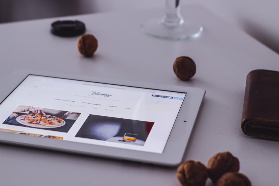 Free Image of Tablet viewed on a desk with snacks nearby 