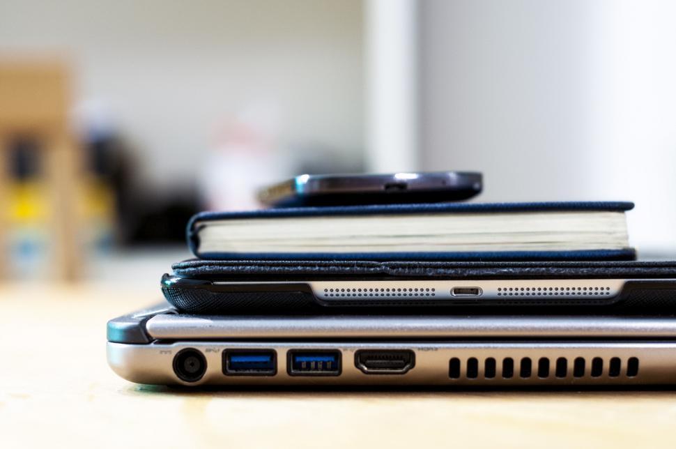 Free Image of Stacked gadgets and notebook on desk 