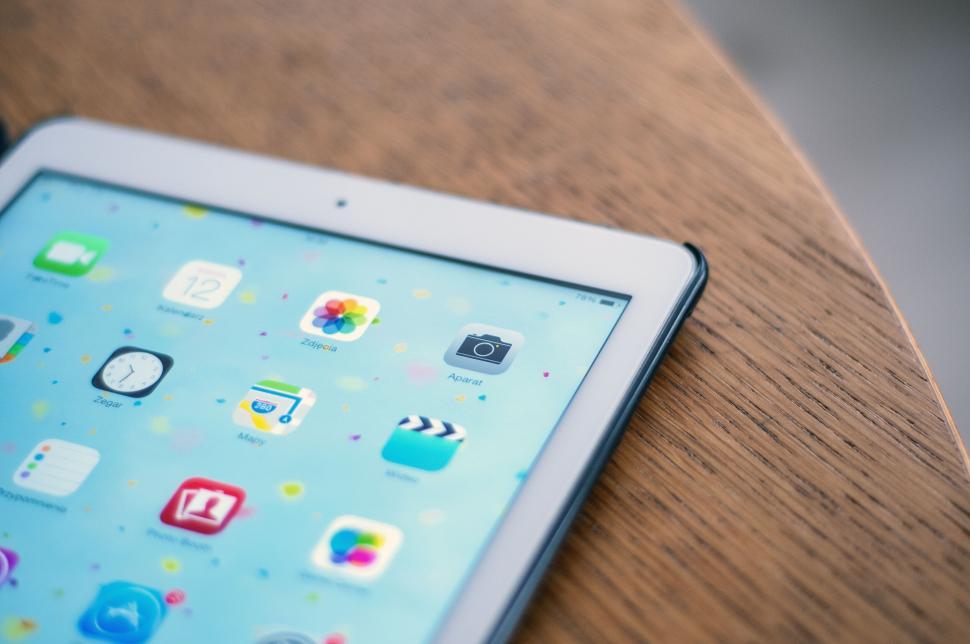 Free Image of Tablet with colorful apps on wooden table 