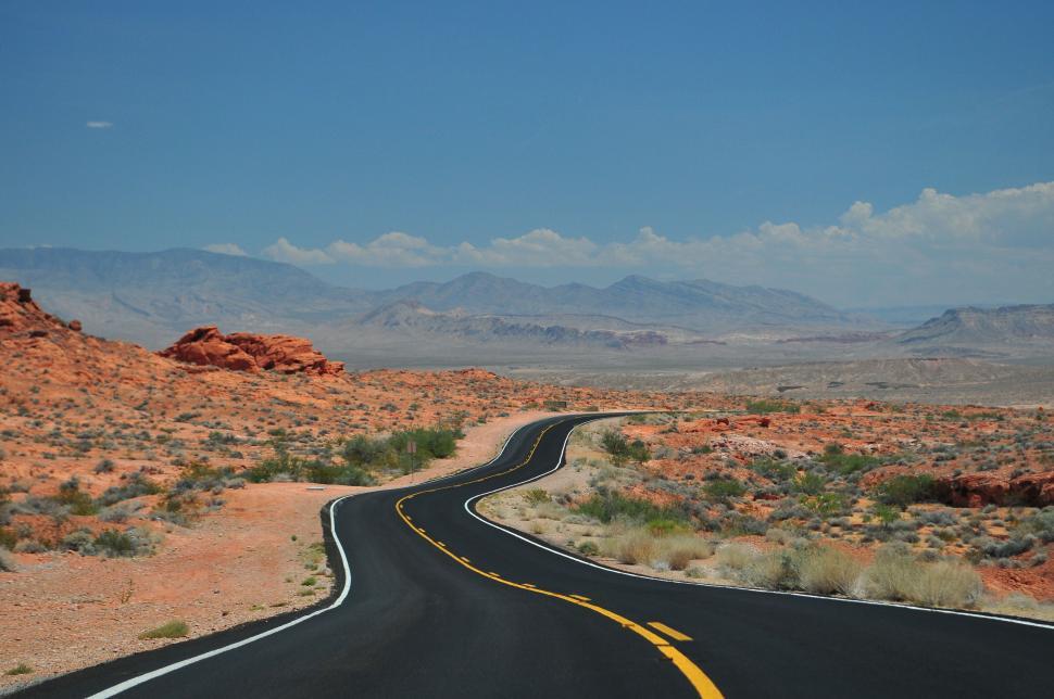 Free Image of Desert road curving through arid landscape 