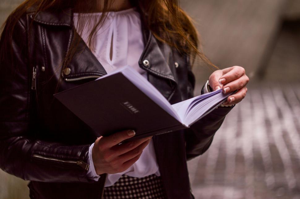 Free Image of Woman browsing through a notebook 