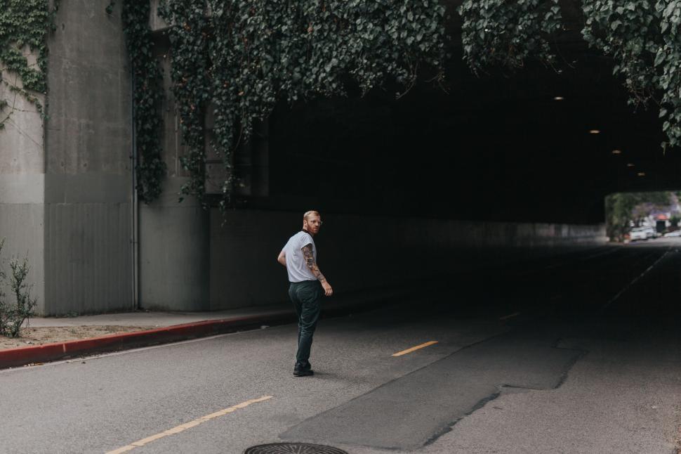 Free Image of Man in casual clothes walking in tunnel 