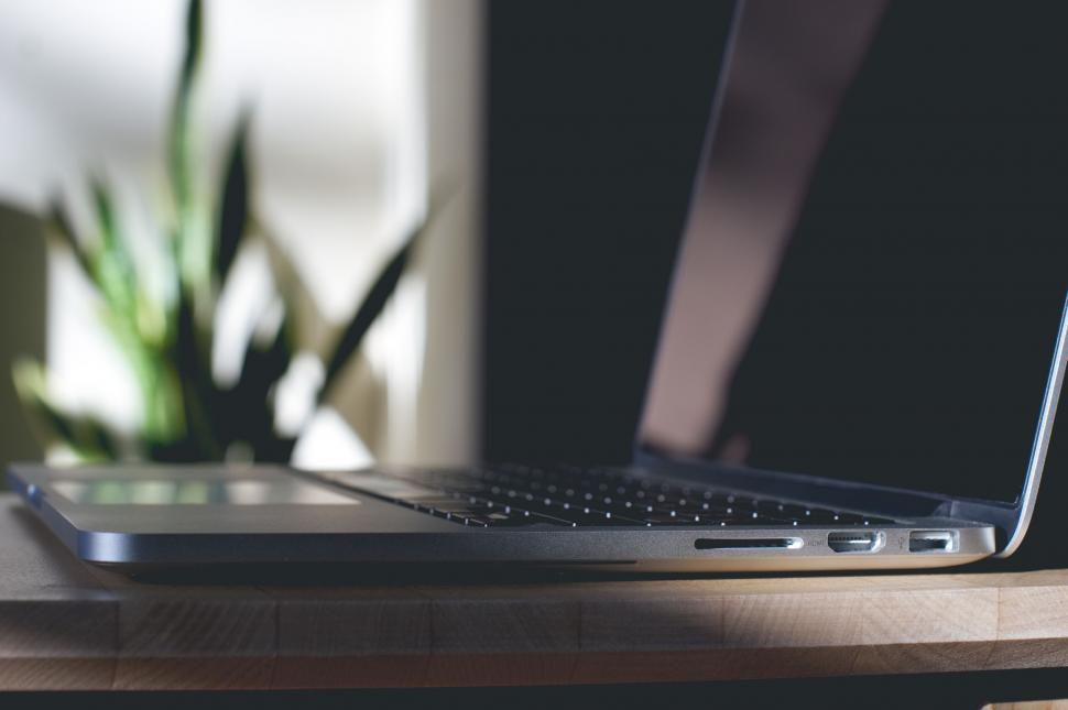 Free Image of Laptop on wooden table with soft lighting 