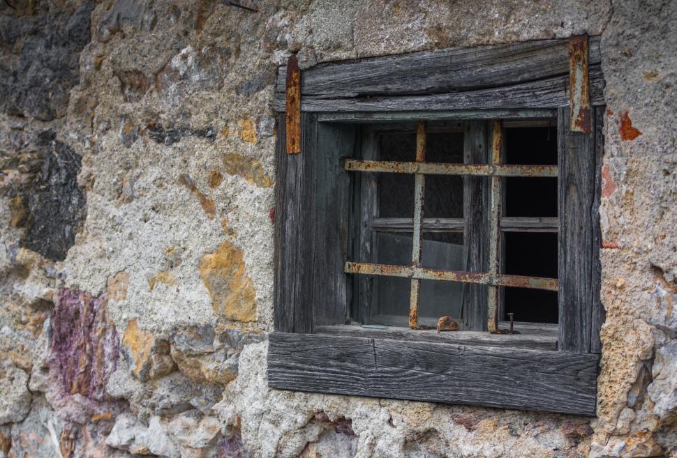 Free Image of Old rustic window on a textured stone wall 