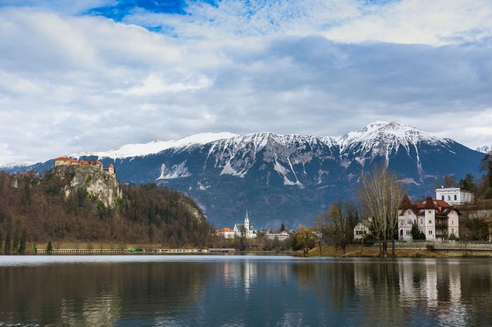 Free Image of Scenic view of a lake with castle and snowy peaks 