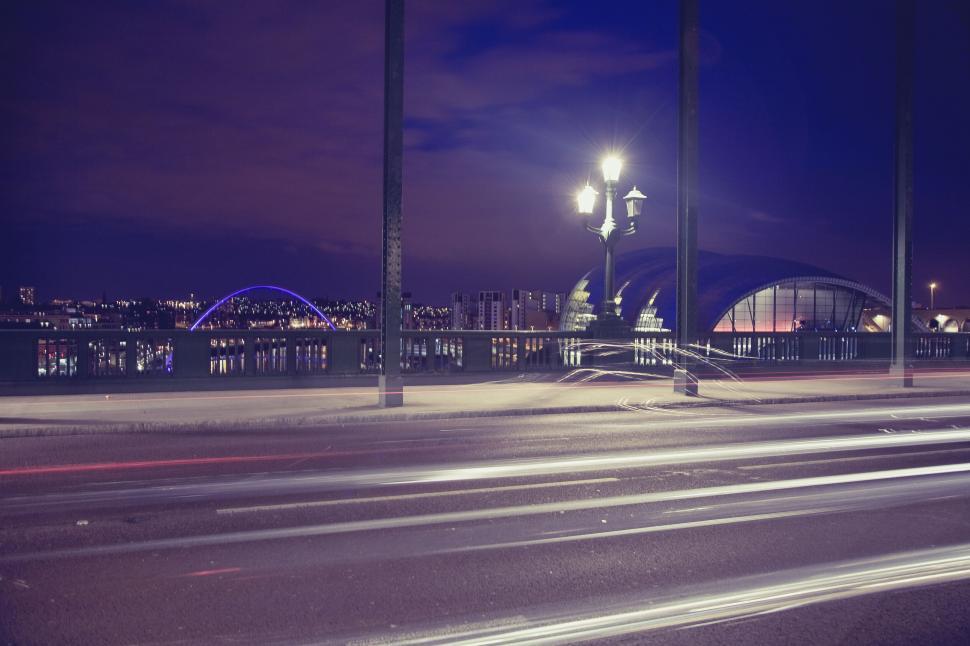 Free Image of Nighttime cityscape with light trails and bridge 