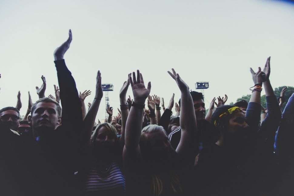 Free Image of Crowd at a concert with raised hands 