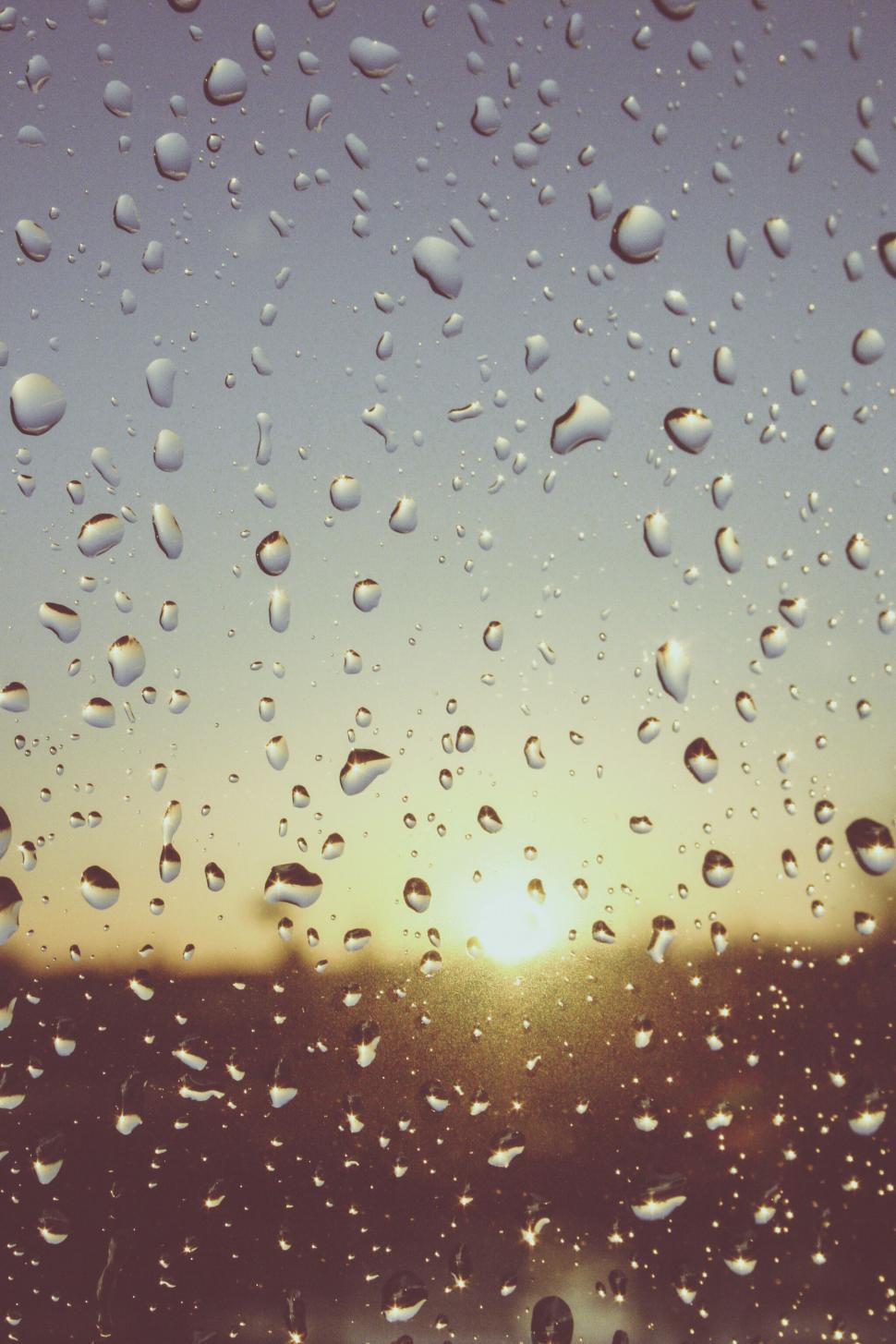 Free Image of Water droplets on window against sunset 