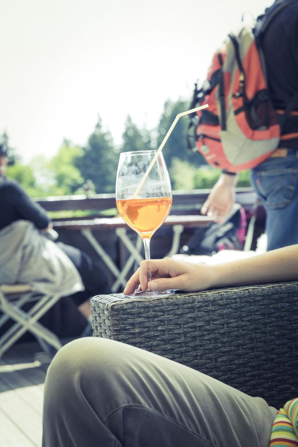 Free Image of Person holding a glass of orange drink outdoor 