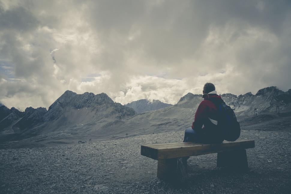 Free Image of Man sitting alone on a mountain bench 