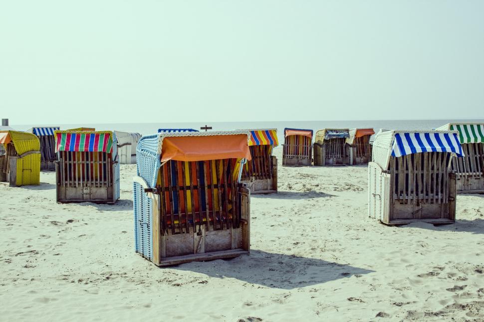Free Image of Colorful beach chairs lined up on sandy beach 