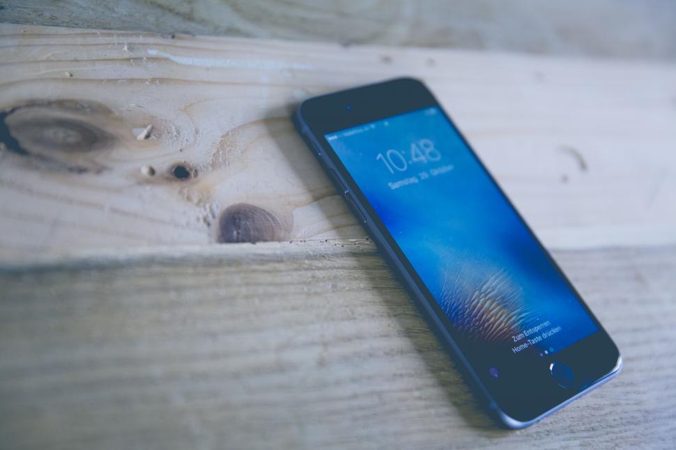 Free Image of Smartphone on a rustic wooden surface displaying time 
