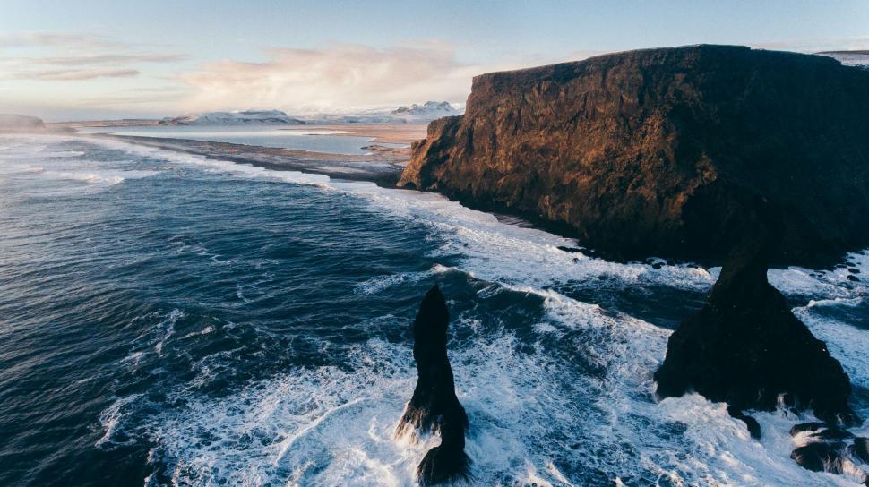 Free Image of Cliffside by the ocean with strong waves 