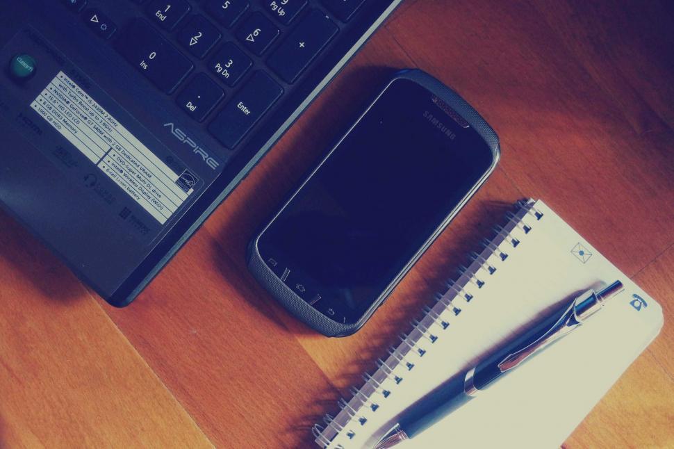 Free Image of Laptop with phone and notepad on desk 
