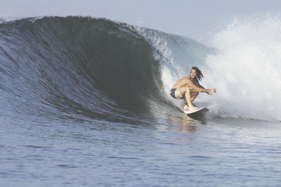 Free Image of Surfer catching a wave in clear blue water 