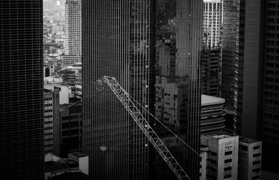 Free Image of B&ampW cityscape with a crane among tall buildings 