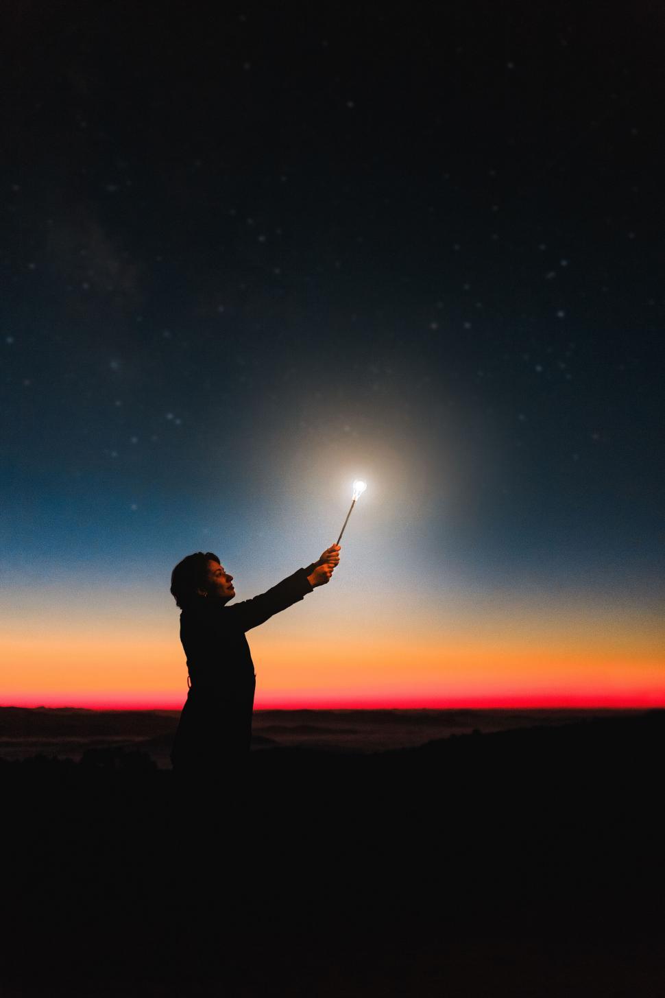 Free Image of Person Holding a Star Against Night Sky 
