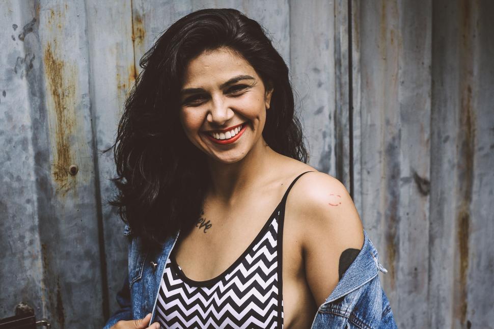 Free Image of Woman in striped tank top laughing happily 