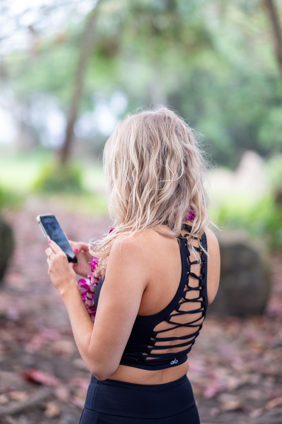 Free Image of Woman using smartphone in natural setting 