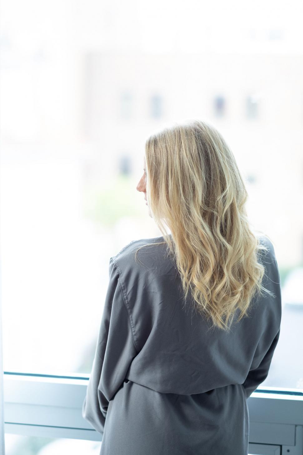 Free Image of Woman gazing out the window in thought 