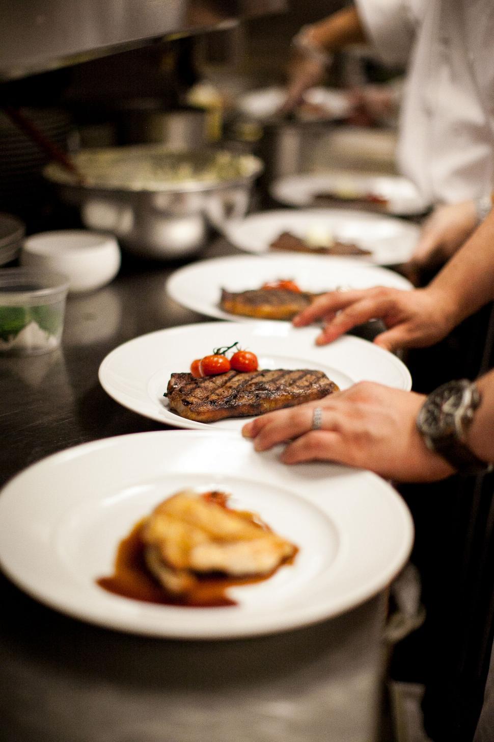 Free Image of Chefs plating gourmet dishes in kitchen 