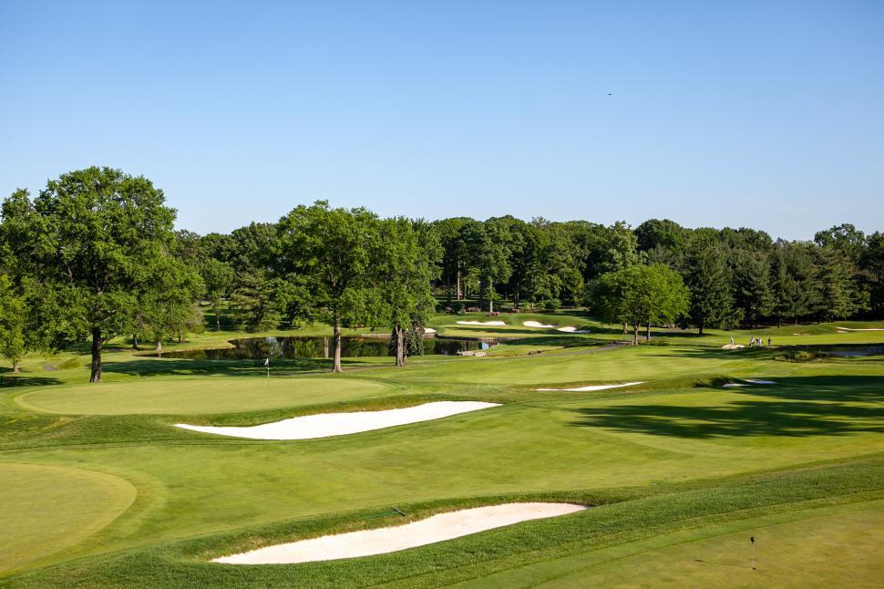 Free Image of Sunny golf course with trees and bunkers 