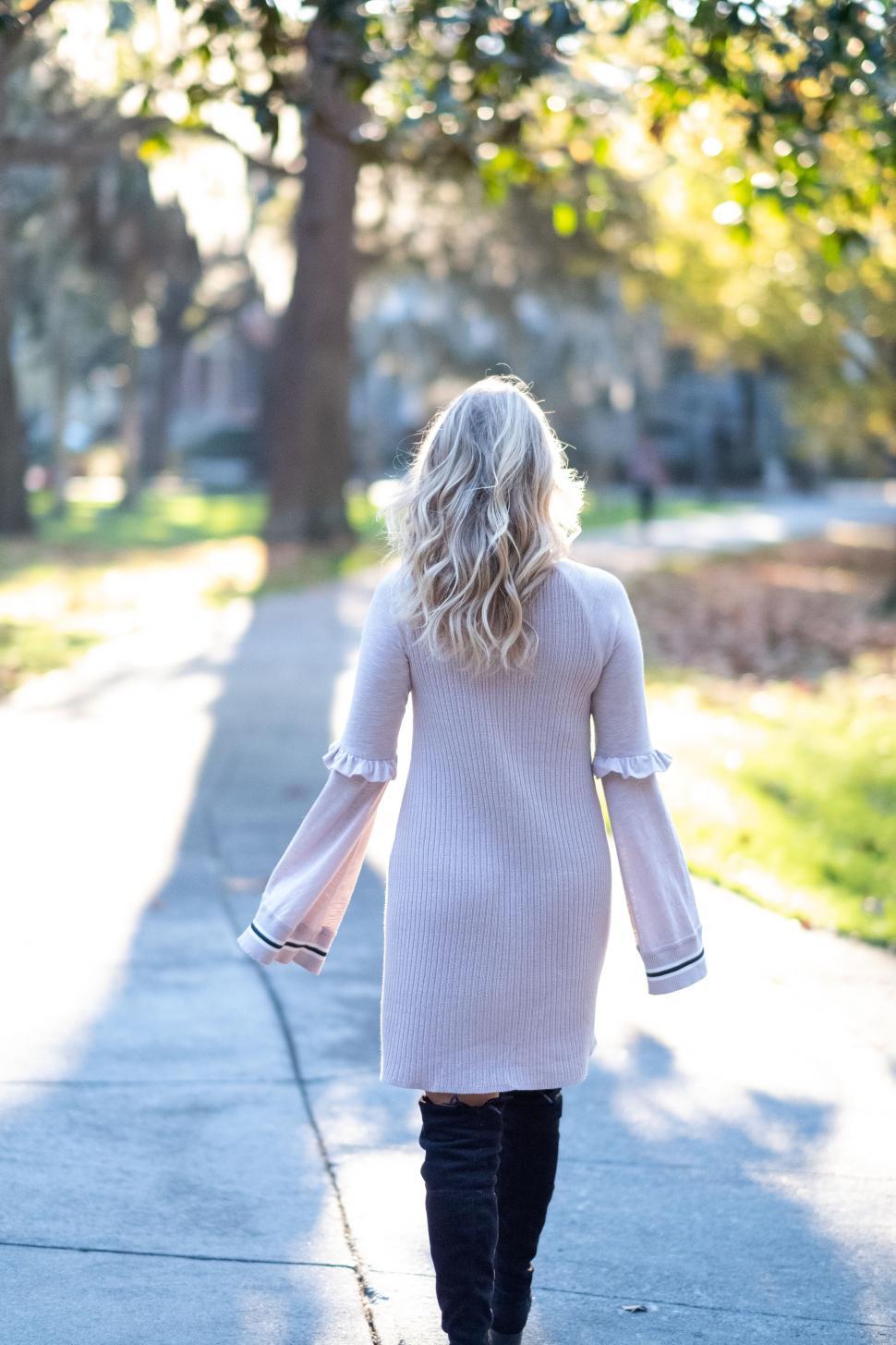 Free Image of Woman walking on a pathway in sunlight 