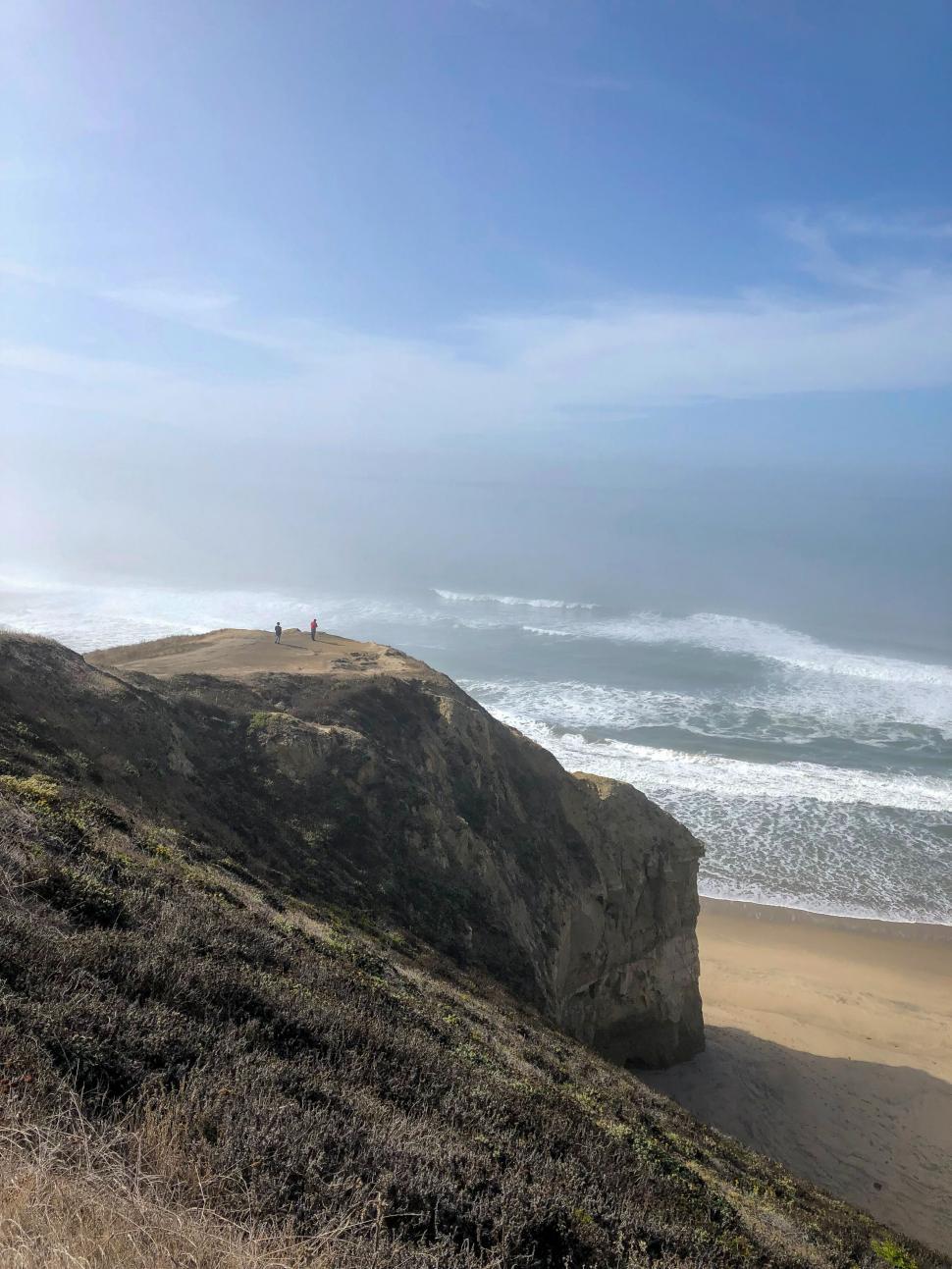 Free Image of Cliffside overlooking beach with people 