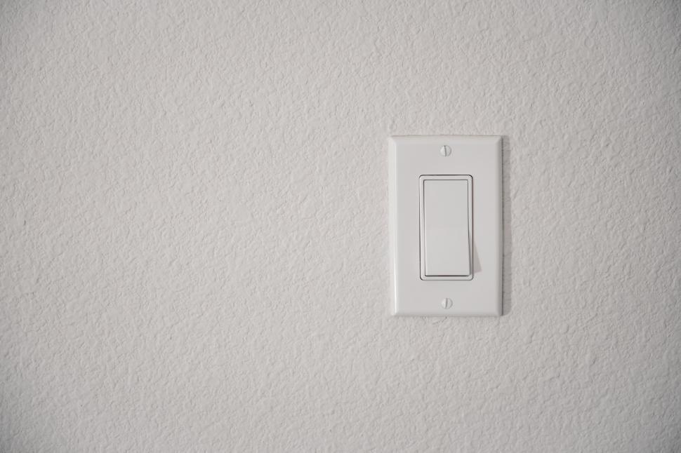 Free Image of White light switch on a textured wall 