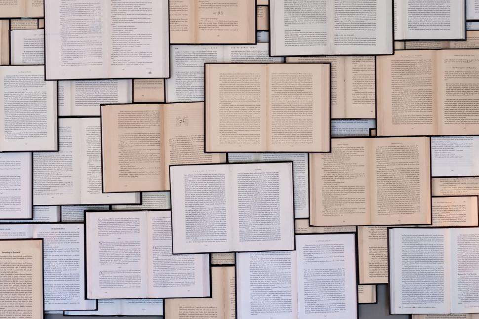Free Image of Wall filled with open books on display 