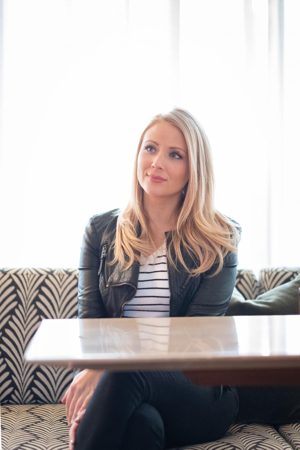 Free Image of Woman seated in a cafe booth, smiling gently 