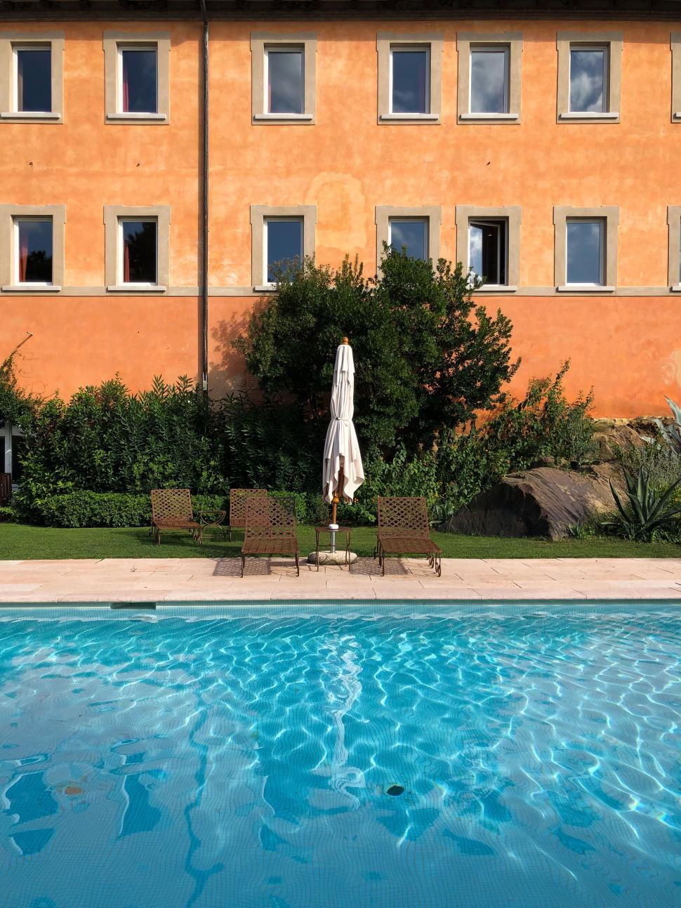 Free Image of Poolside loungers in front of a vibrant building 