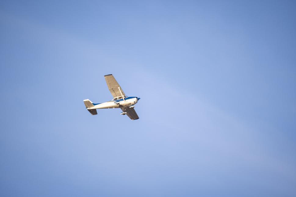 Free Image of Single-engine airplane flying in a clear blue sky 