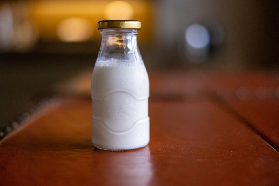 Free Image of Single small milk bottle on wooden table 
