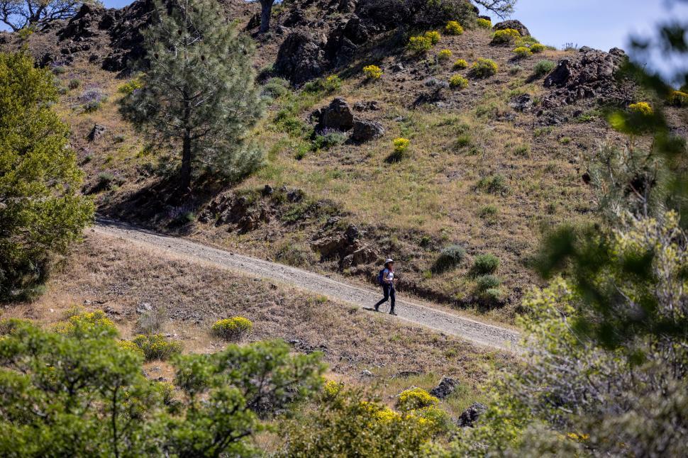 Free Image of Hiker on a desert mountain trail under blue sky 