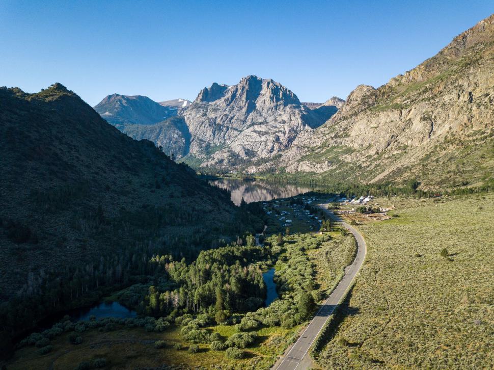 Free Image of Aerial view of a valley with a curvy road and lake 