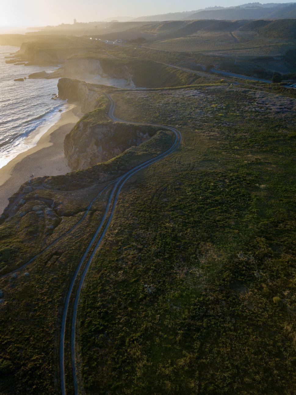 Free Image of Coastal road winding along a cliff at sunset 