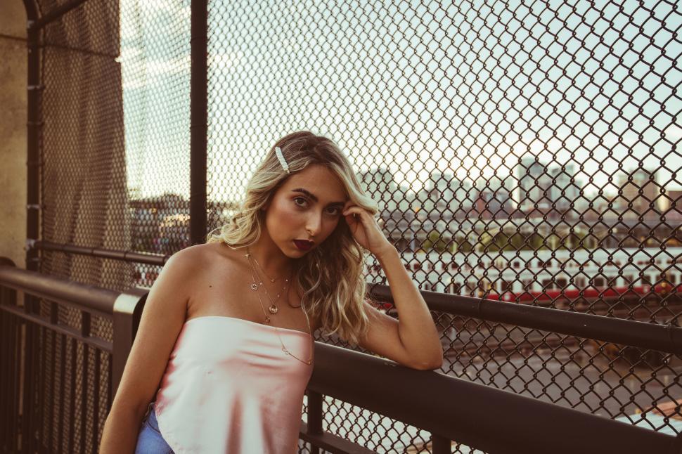 Free Image of Thoughtful woman by city barrier 