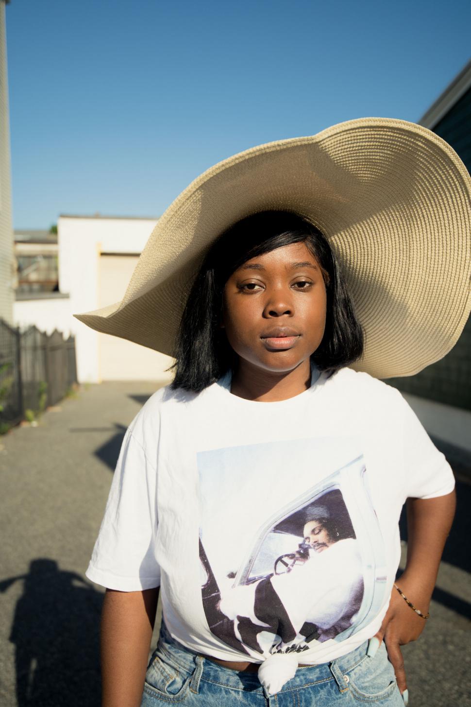 Free Image of Woman with wide-brimmed hat facing sun 