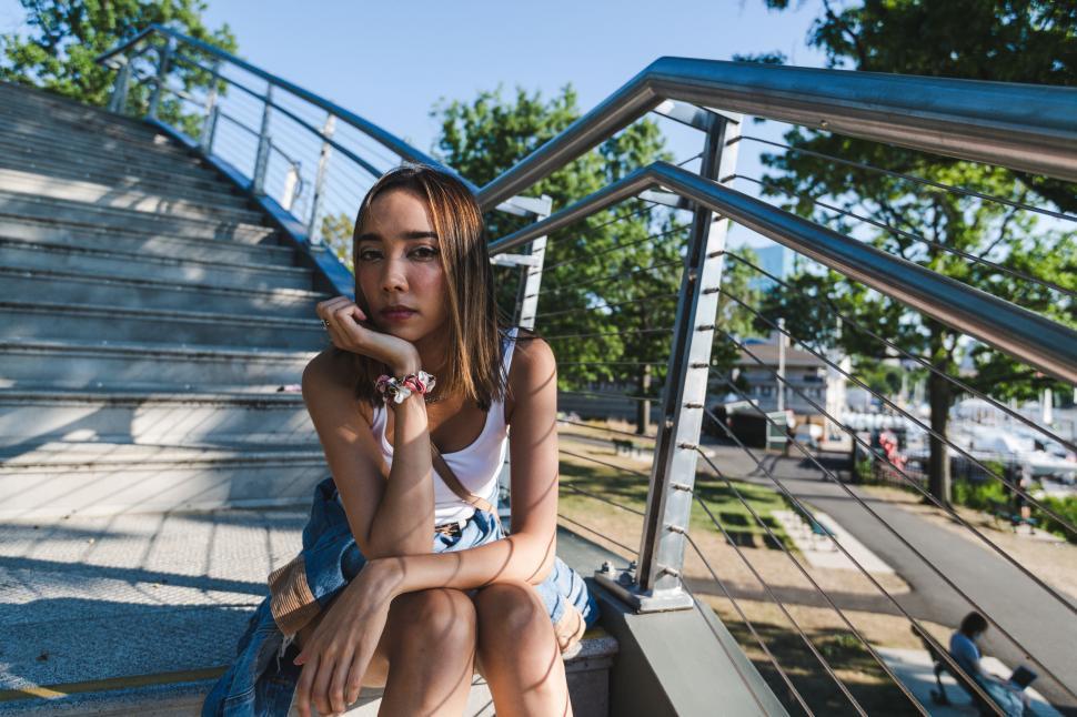 Free Image of Seated woman in contemplative pose on stairs 