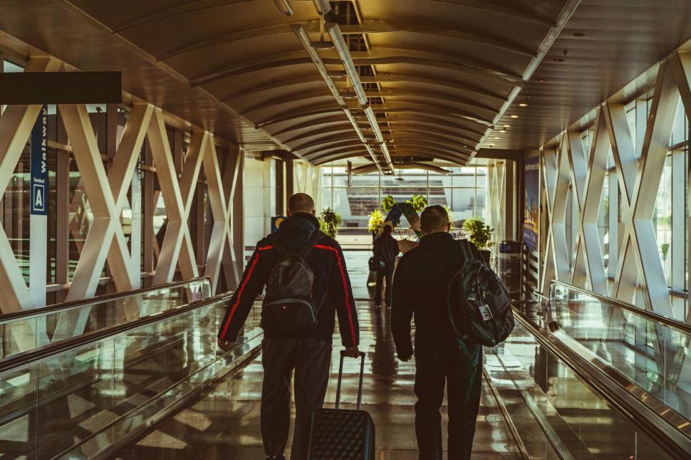 Free Image of Passengers walking through airport walkway 