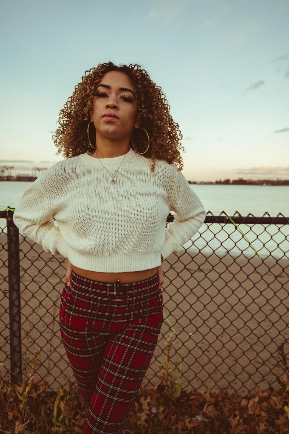 Free Image of Woman striking a pose by the waterfront 