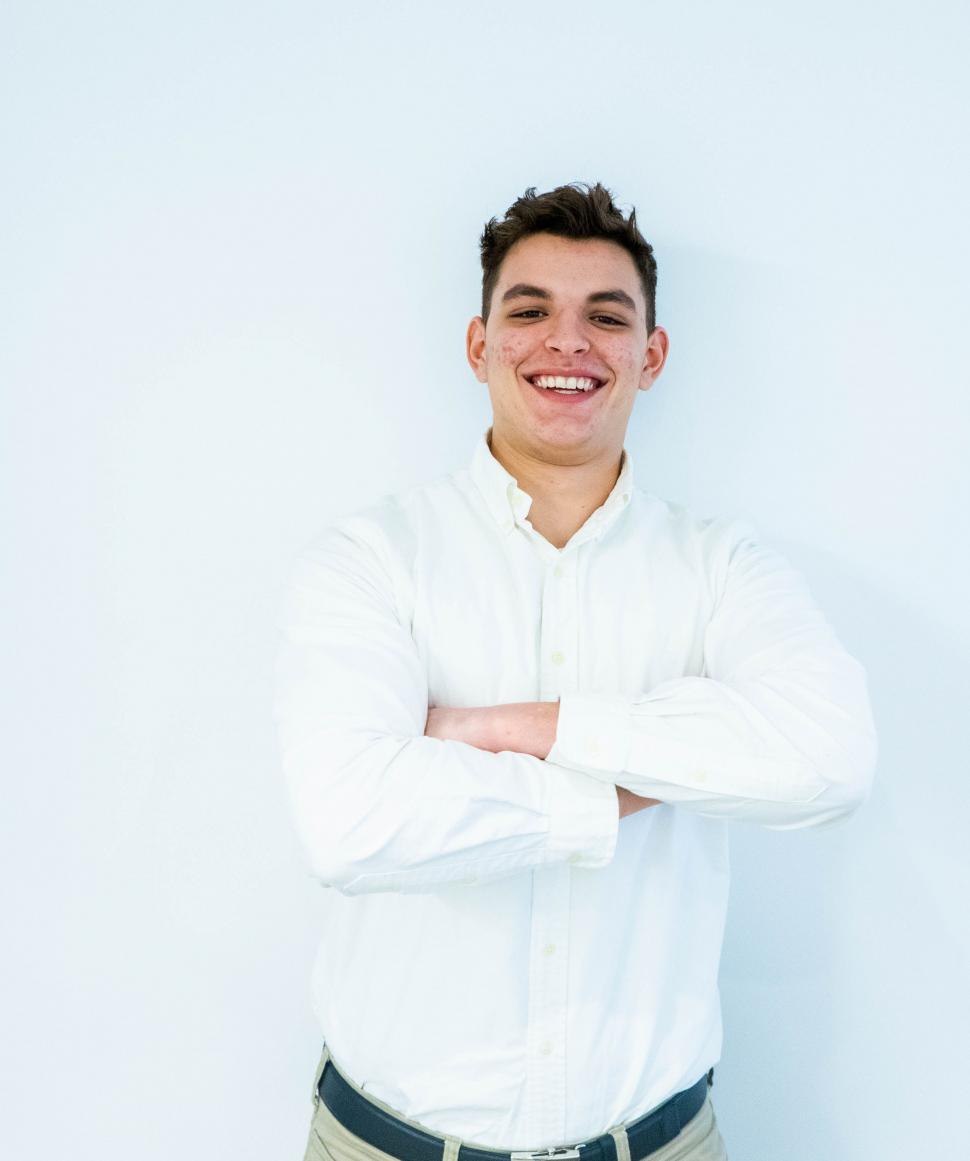Free Image of Smiling man in white shirt with arms crossed 