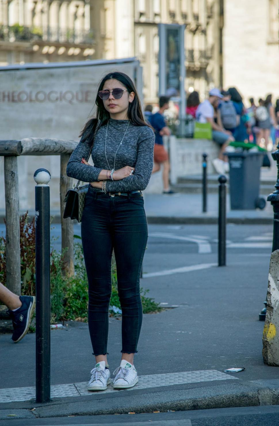 Free Image of Woman standing alone on busy street 